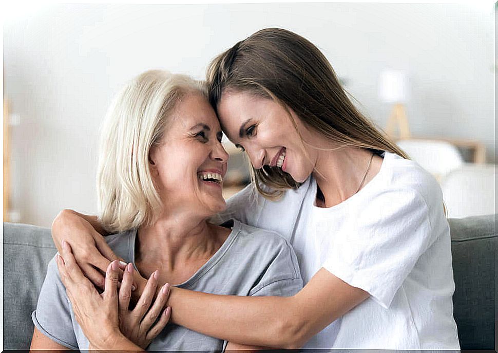 Daughter and mother hugging smiling.