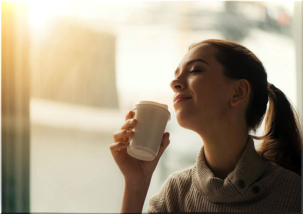 Woman appreciating the aroma of coffee.