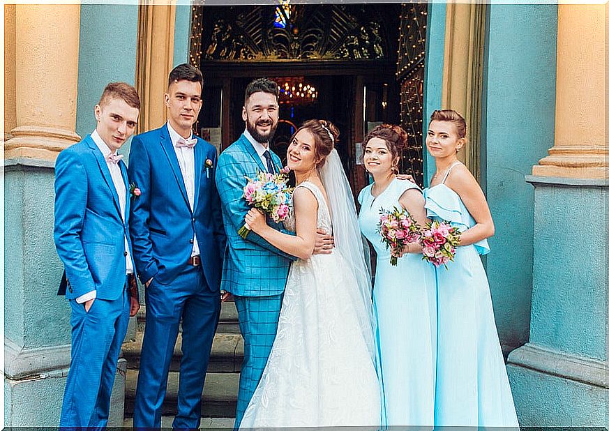 Bride and groom and groomsmen posing at the church door