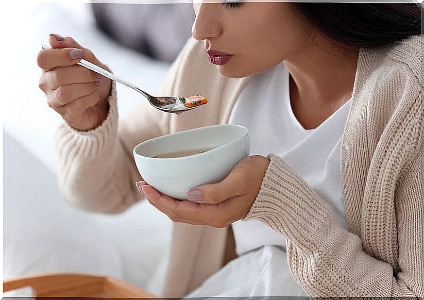 Woman eating bowl of soup.