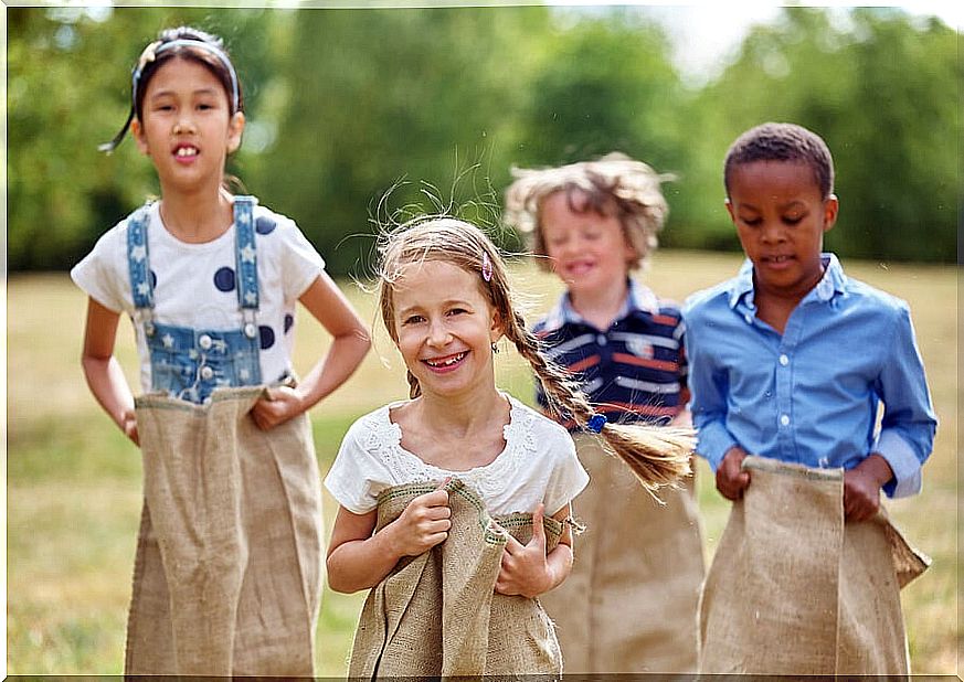 Children playing outdoors with sacks